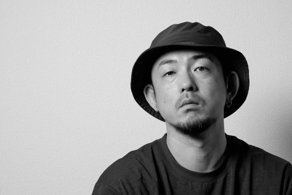 福井を拠点に全国対応するDESIGN STUDIO FUU（デザインスタジオフウ）の代表カメラマン松山文弥のプロフィール写真。モノトーンの洗練されたライティングでプロの風格とクリエイティブな空気感を表現した高品質なポートレート。